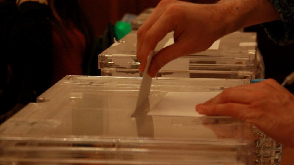 Un elector diposita un vot en una urna
